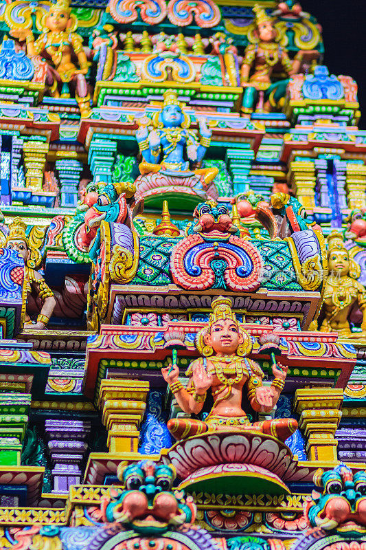 在Sri Maha Mariamman寺庙，也被称为Maha Uma Devi寺庙，在Silom，泰国曼谷，公共印度教寺庙印度神雕塑的彩色夜景。它被称为Wat Khaek Silom。